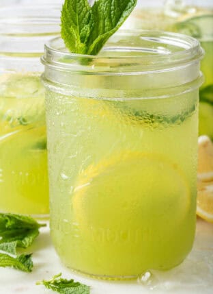 Two clear glass mason jars filled with Cucumber Lemonade.