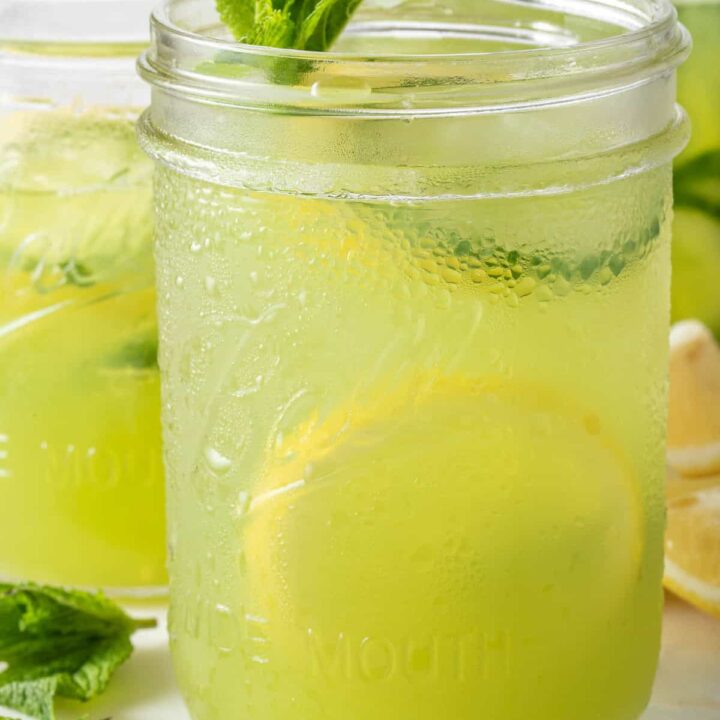 Two clear glass mason jars filled with Cucumber Lemonade.