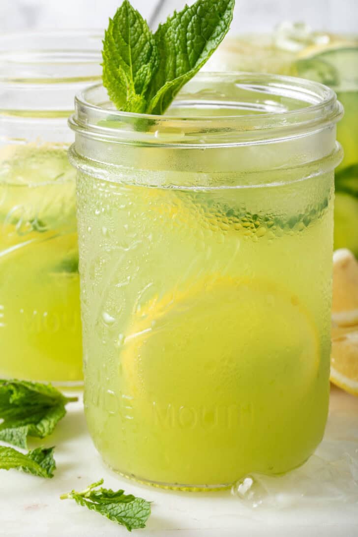 Two clear glass mason jars filled with Cucumber Lemonade.