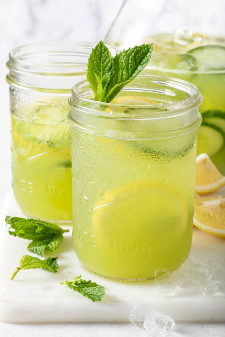 Two clear glass mason jars filled with light green juice.