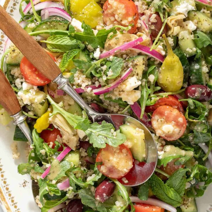 A white oval platter filled with Greek Quinoa Salad.