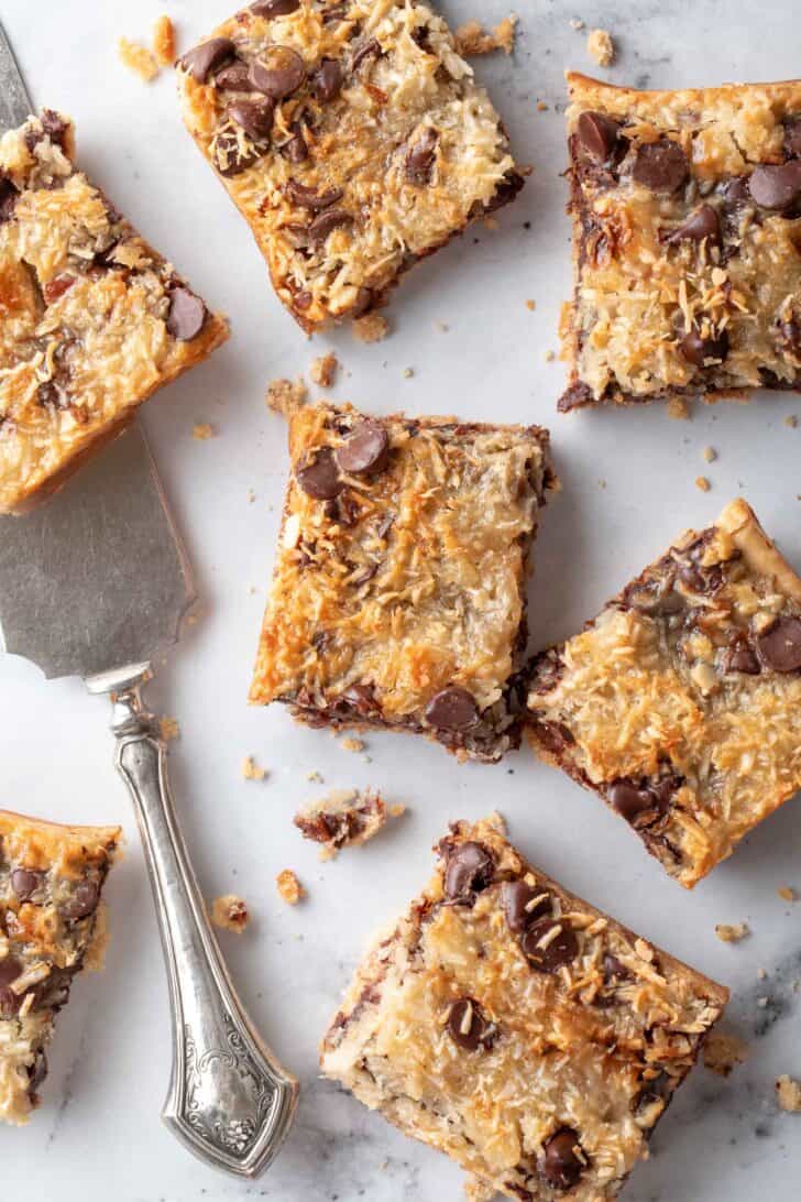 Six pieces of Magic Cookie Bars set on a marble background. 