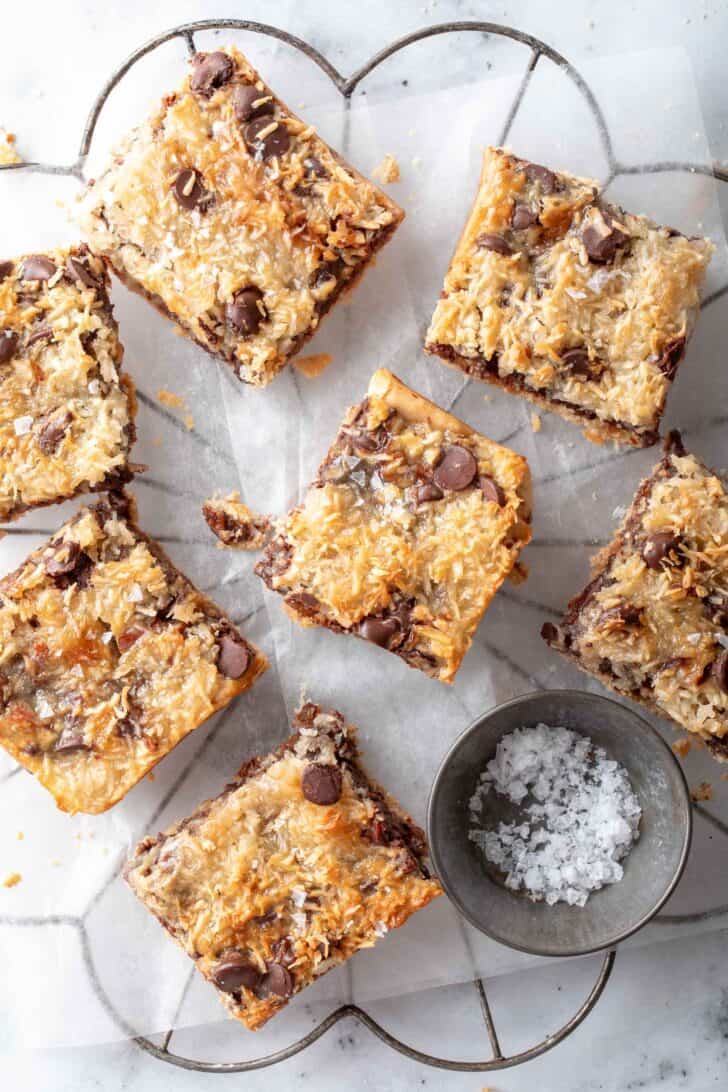 Seven square pieces of dessert resting on a wire cooling rack.