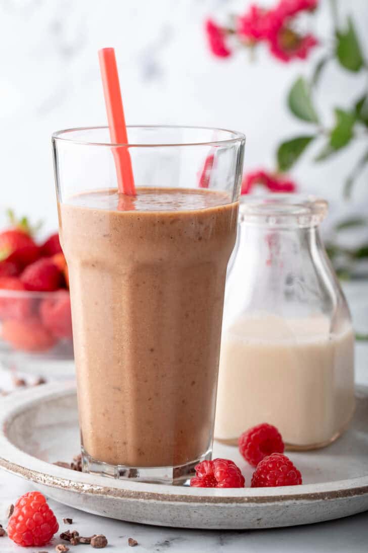 A clear drinking glass filled with a creamy drink.