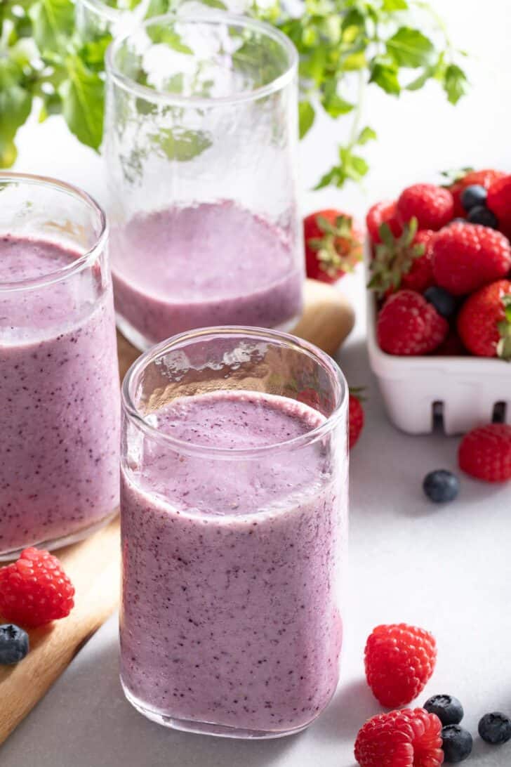 Three clear glasses filled with Mixed Berry Smoothie.