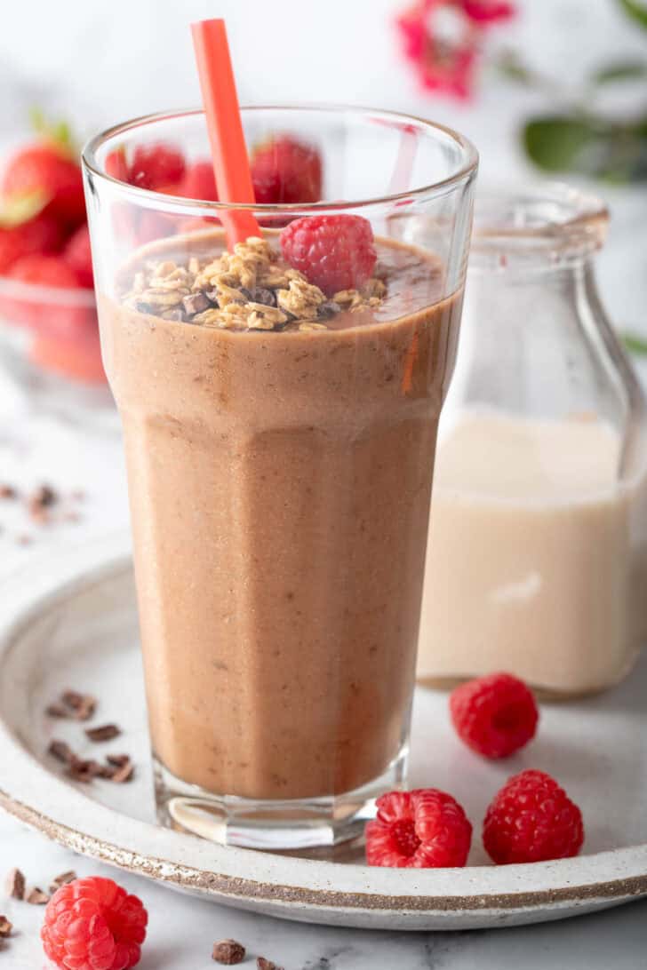 A clear drinking glass filled with Chocolate Banana Smoothie. 