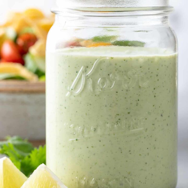 A clear glass mason jar filled with Cilantro Ranch Dressing.