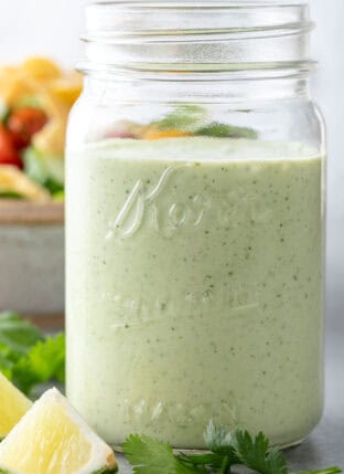 A clear glass mason jar filled with Cilantro Ranch Dressing.