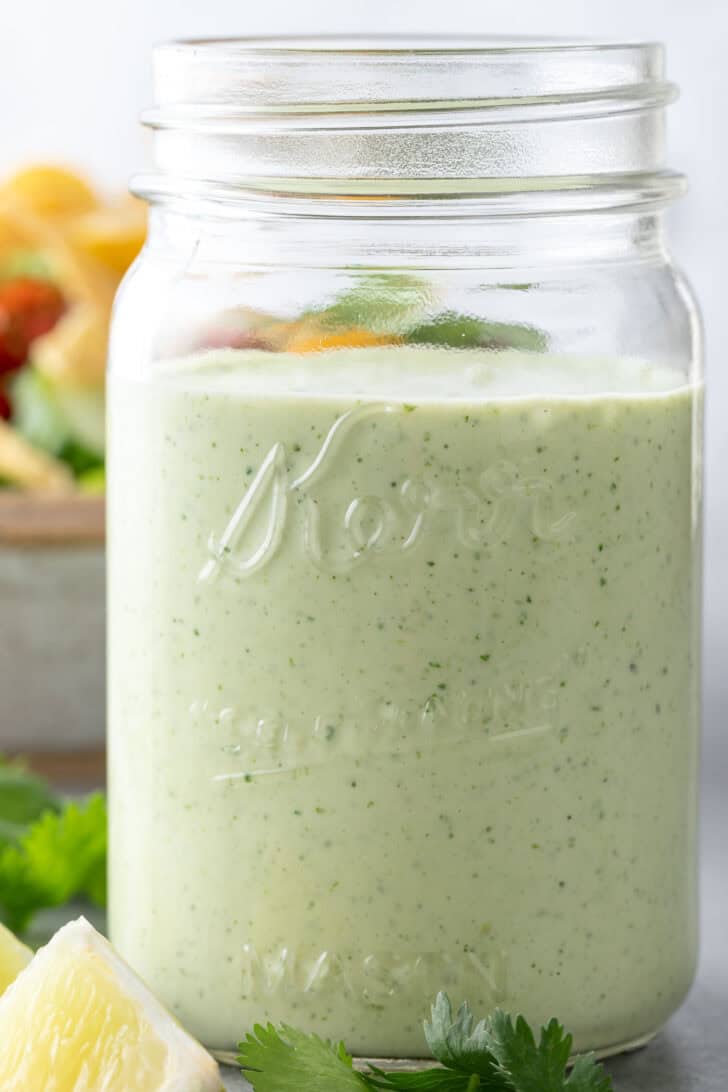 A clear mason jar filled with a creamy sauce.