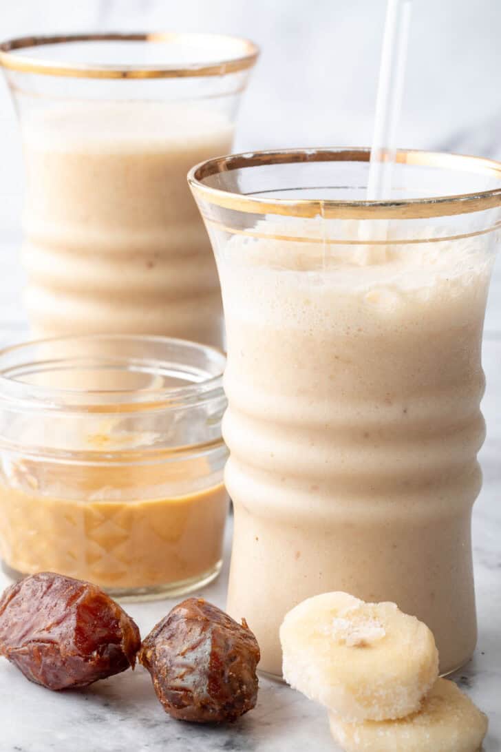 Two clear drinking glasses filled with Date Shake.