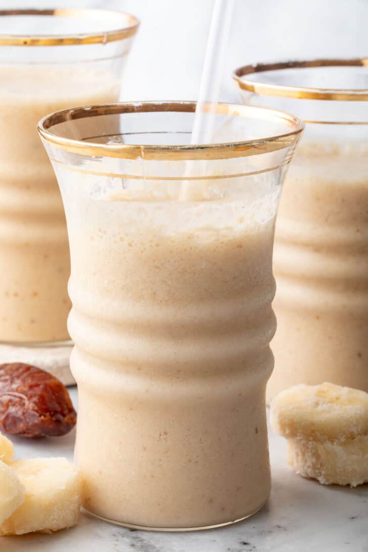 Three clear drinking glasses filled with Date Shakes.