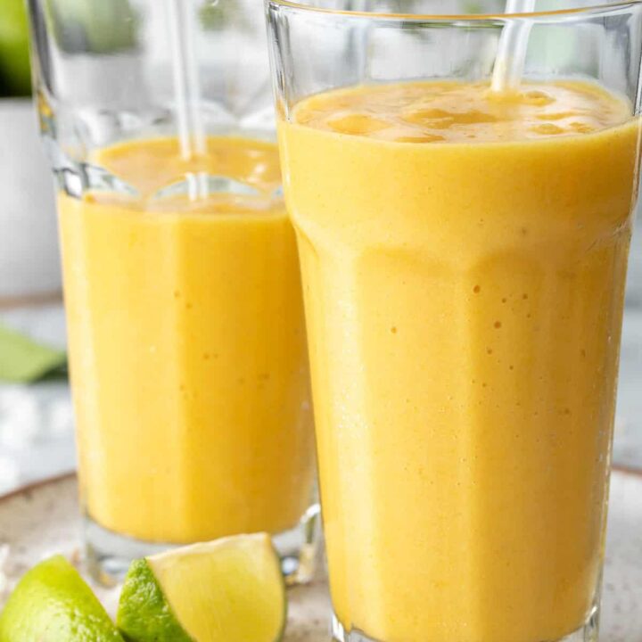 Two clear drinking glasses filled with pineapple Mango Smoothie.