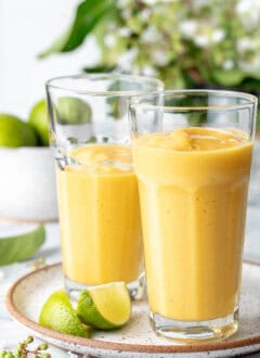 Two clear drinking glasses filled with fruit shake.