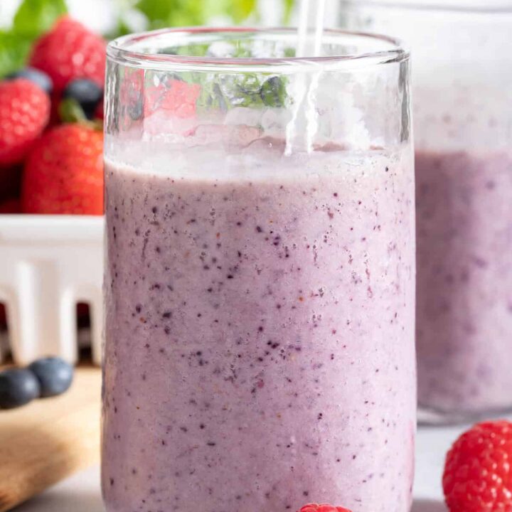 Two clear glasses filled with Mixed Berry Smoothie.