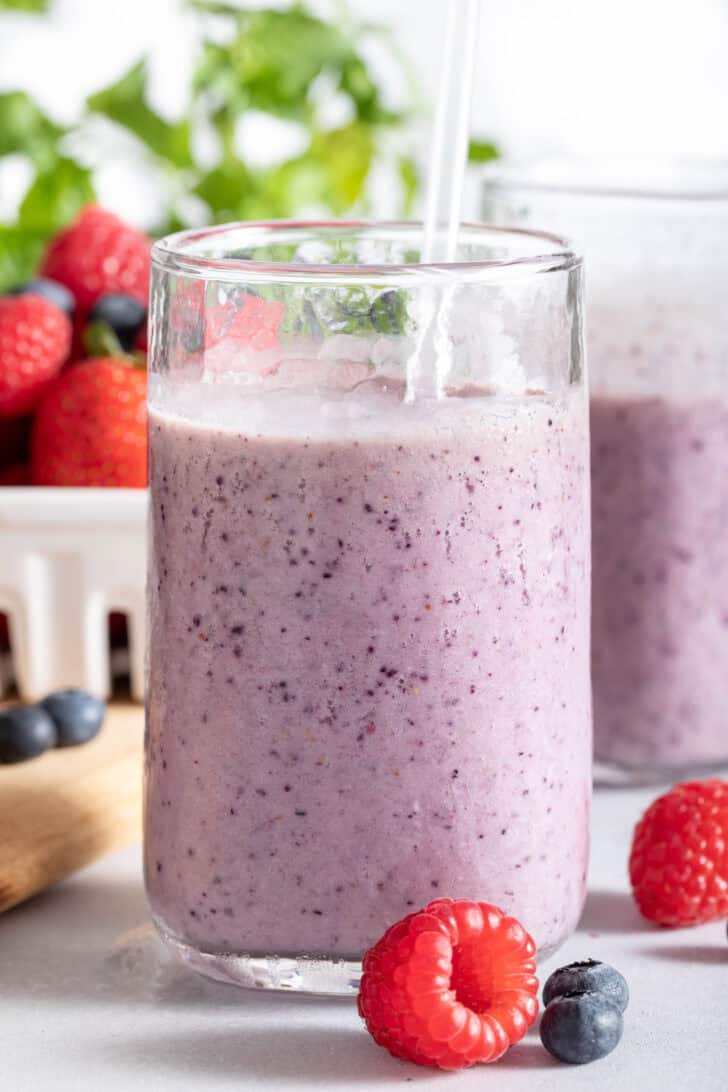 Two clear glasses filled with Mixed Berry Smoothie.