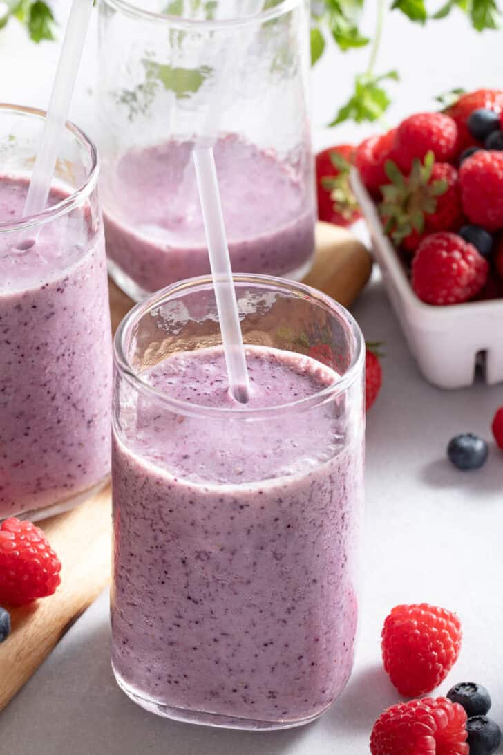 Three clear glasses filled with Berry Smoothie.