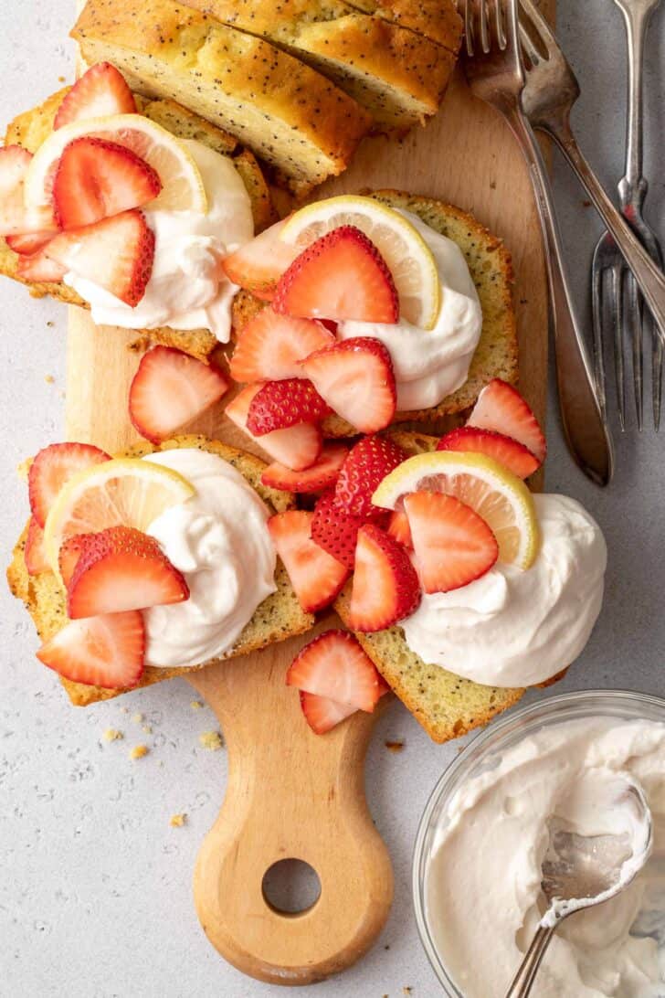 Slices of pound cake topped with Mascarpone Whipped Cream and garnished with slices of strawberries.