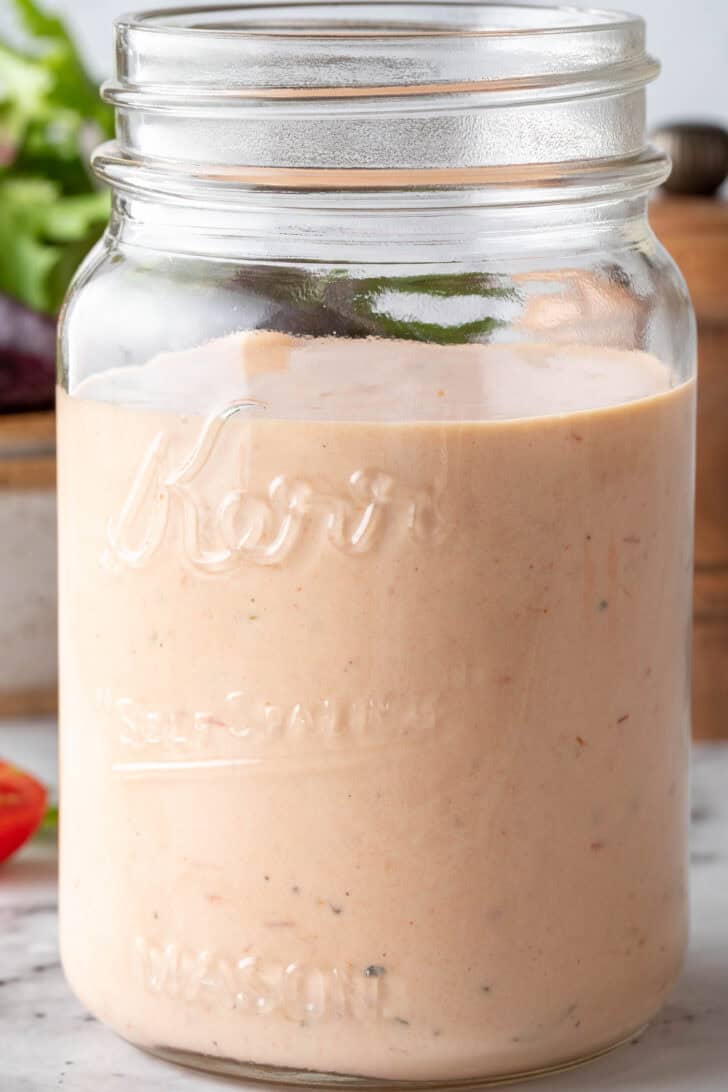 A clear mason jar filled with 1000 Island Dressing.