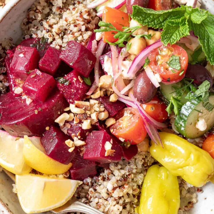 A Mediterranean Bowl filled with quinoa, Greek cucumber salad, marinated beets and toasted nuts.