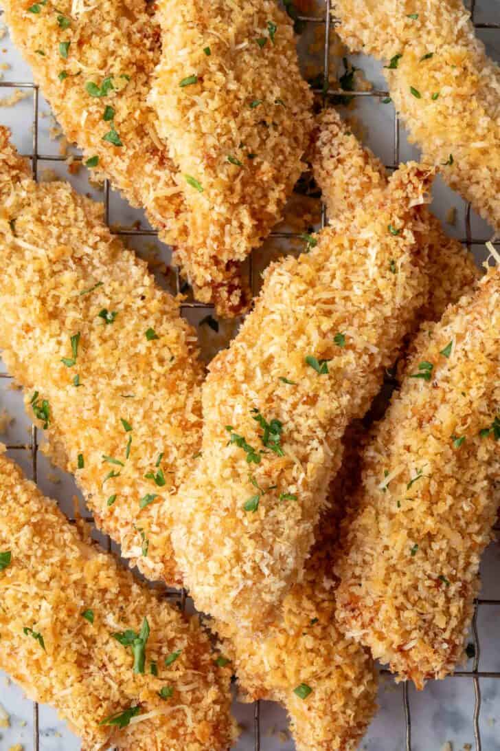 A pile of baked chicken tenders on a wire cooling rack.