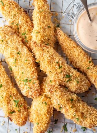 A pile of Baked Chicken Tenders on a wire cooling rack.