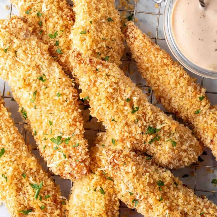 A pile of Baked Chicken Tenders on a wire cooling rack.