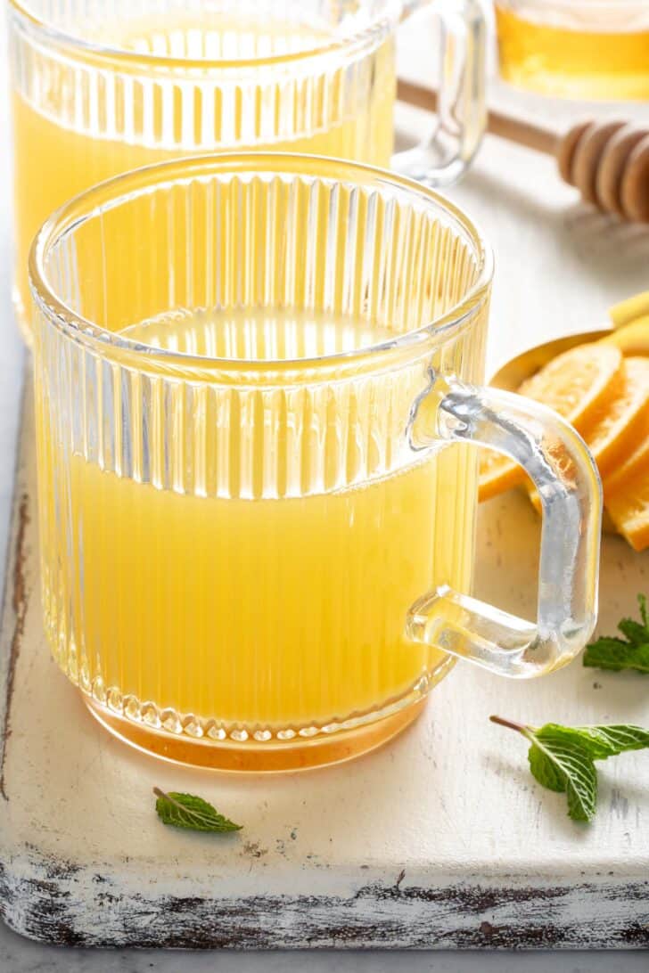 Two clear mugs filled with green tea and apple cider vinegar.