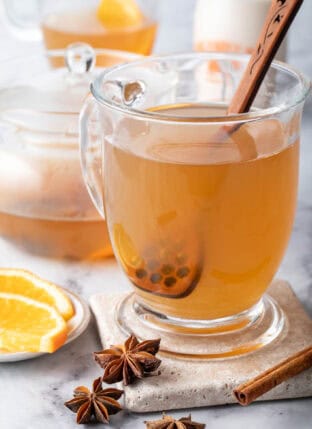 A clear glass mug filled with Chai Green Tea.