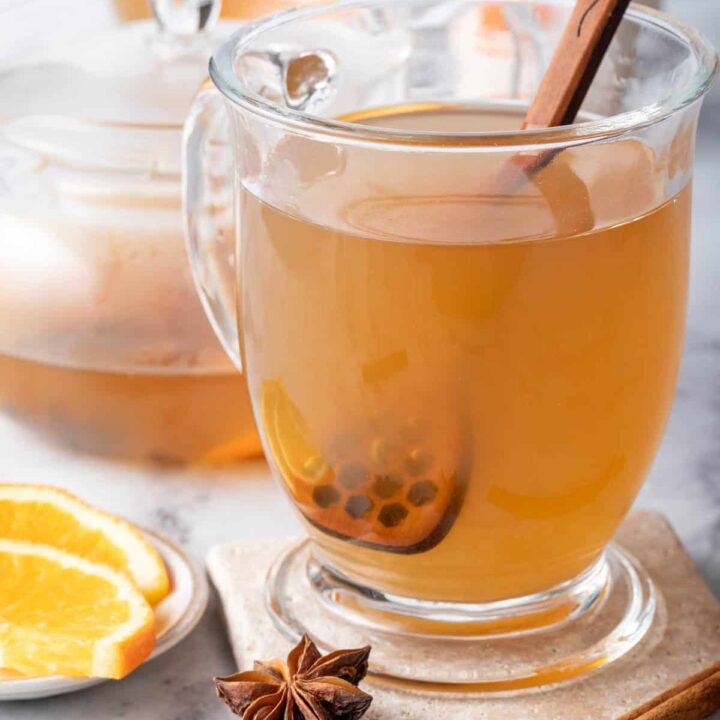 A clear glass mug filled with Chai Green Tea.