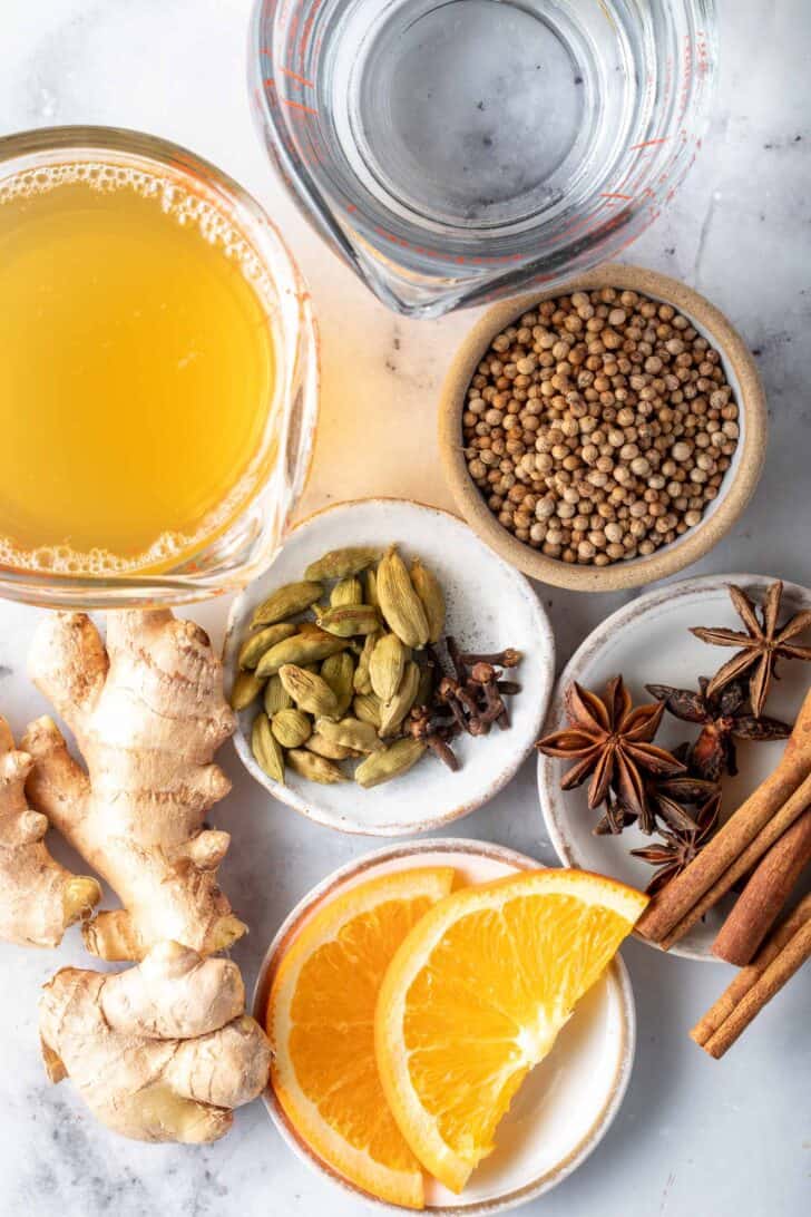 Small cups filled with spices and glass measuring cups filled with water and tea.