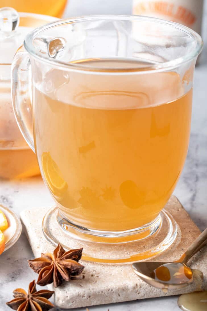 A clear glass mug filled with chai green tea.