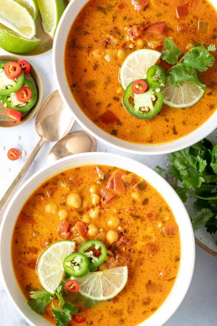 Two white bowls filled with coconut curry chickpea soup