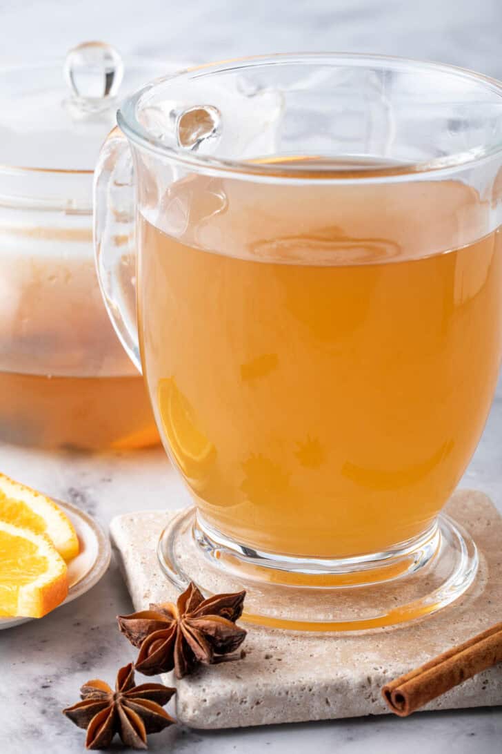 A clear glass mug filled with a hot drink.