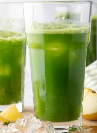 Two clear glasses filled with healthy green juice.