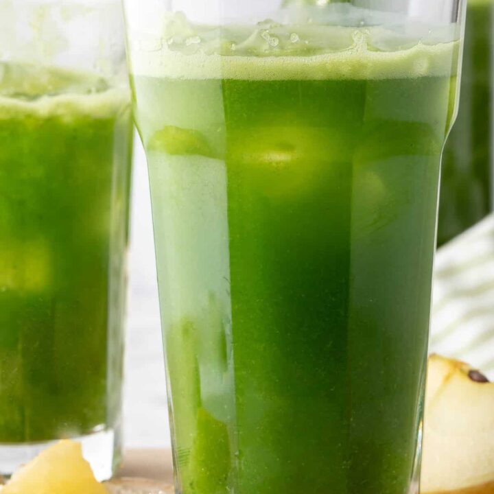 Two clear glasses filled with healthy green juice.