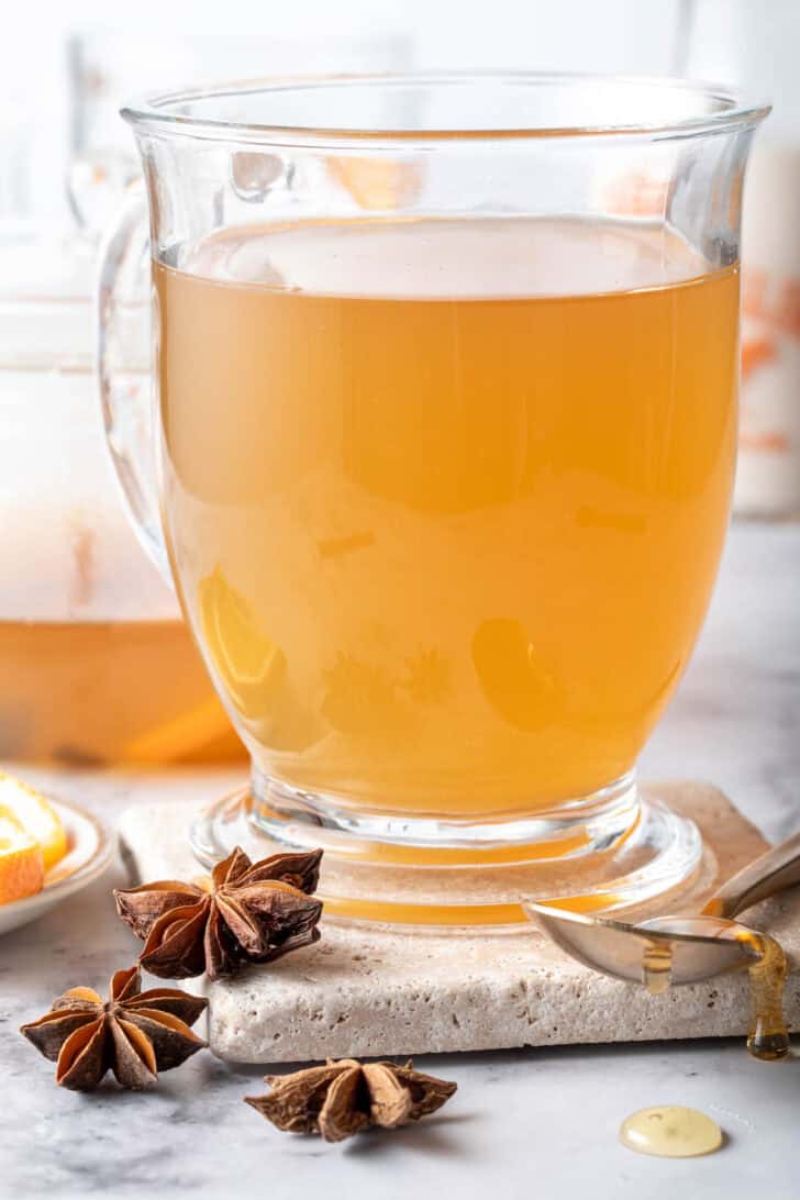 A clear glass mug filled with chai green tea.