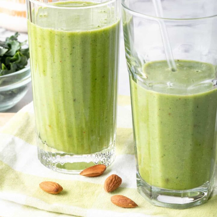 Two drinking glasses filled with kale smoothie.