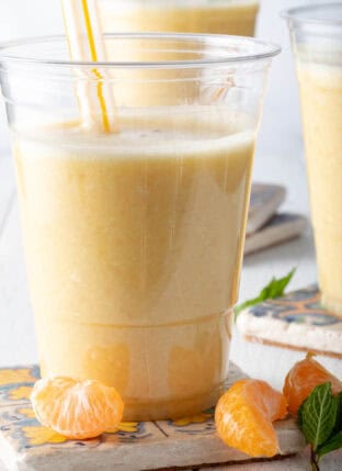 A clear glass filled with Pineapple Smoothie.