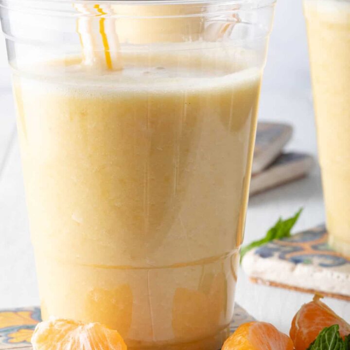 A clear glass filled with Pineapple Smoothie.