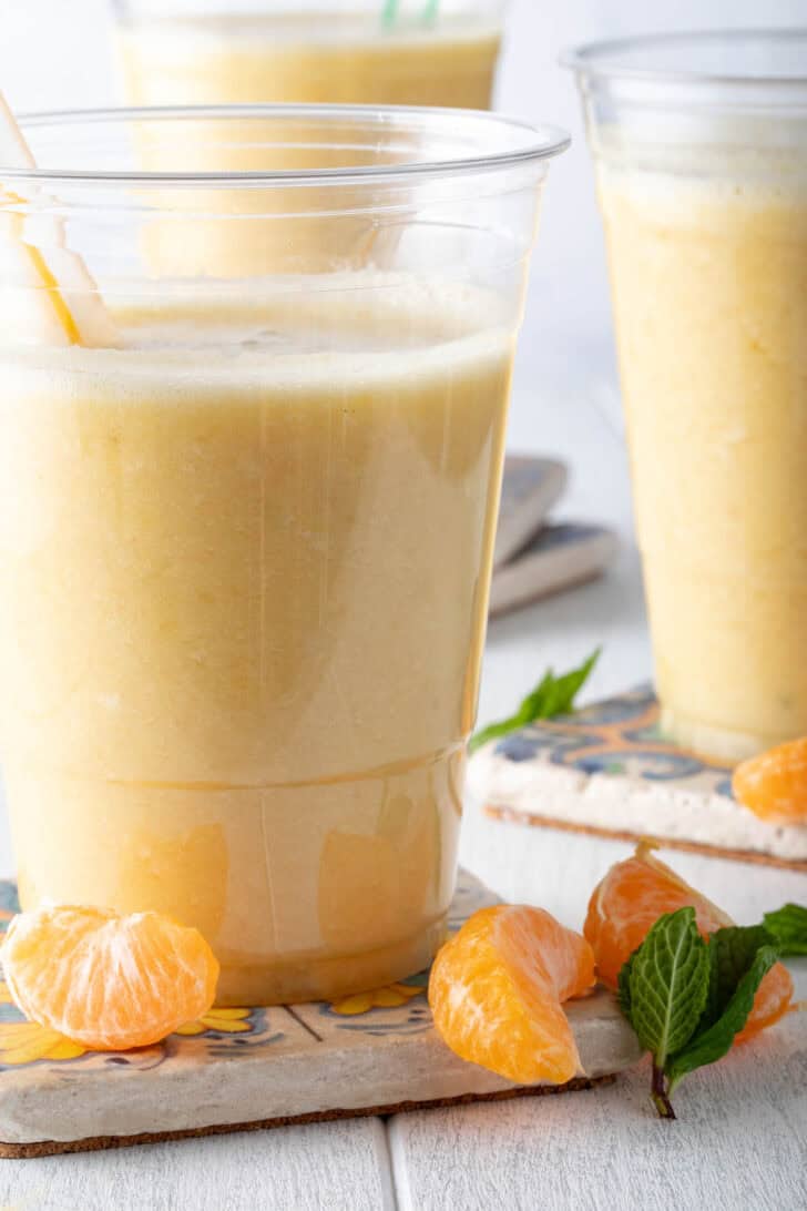 A clear glass filled with Pineapple Banana Smoothie.