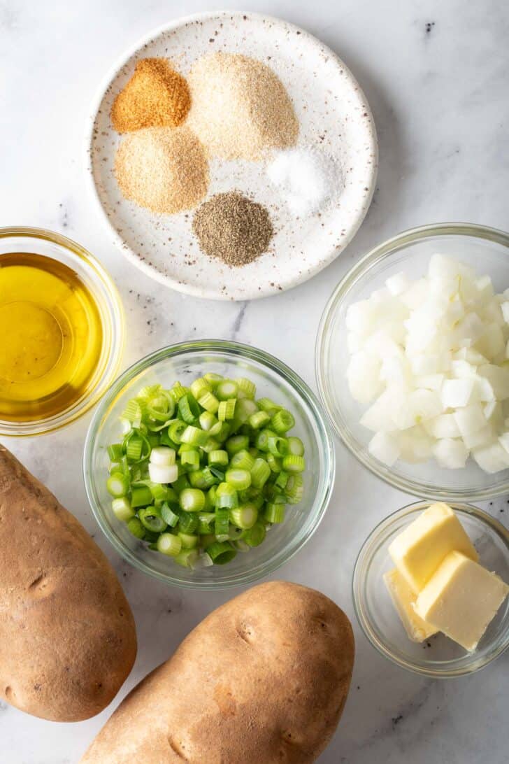 Small glass bowls filled with chopped onion, olive oil, butter and seasoning.