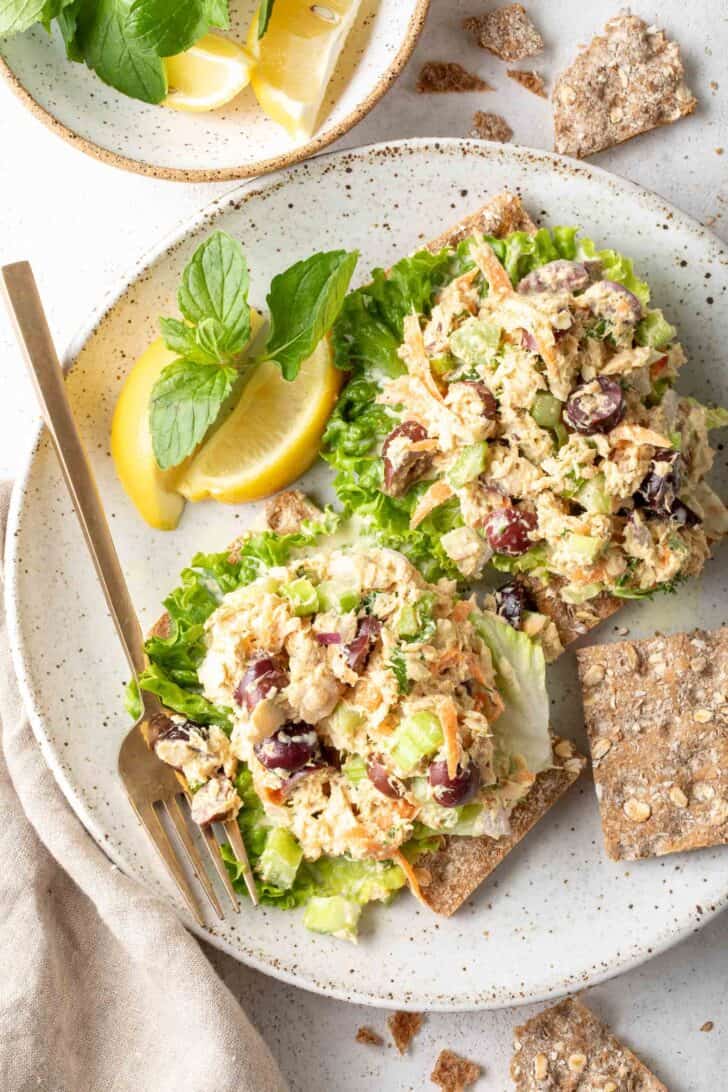 A white plate with two scoops of salmon salad on lettuce leaves.