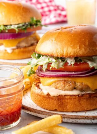 Two juicy ground turkey burgers on plates.