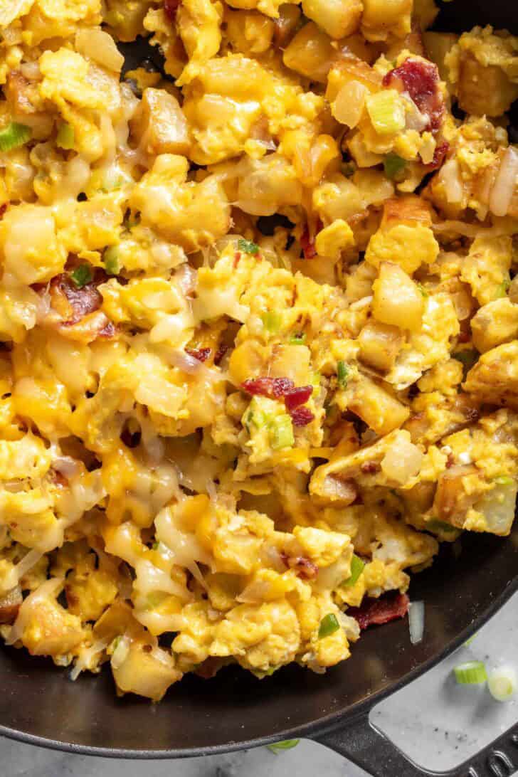 A black skillet filled with Breakfast Scramble with potatoes.