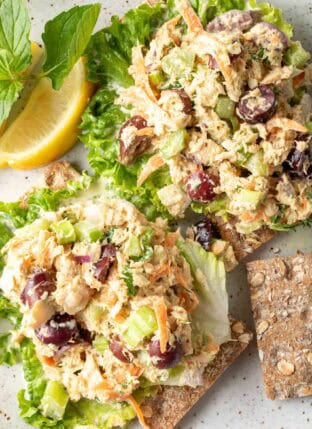 A white plate with two scoops of canned Salmon Salad on lettuce leaves.