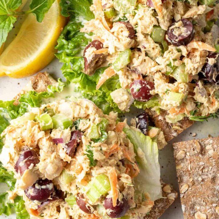 A white plate with two scoops of canned Salmon Salad on lettuce leaves.