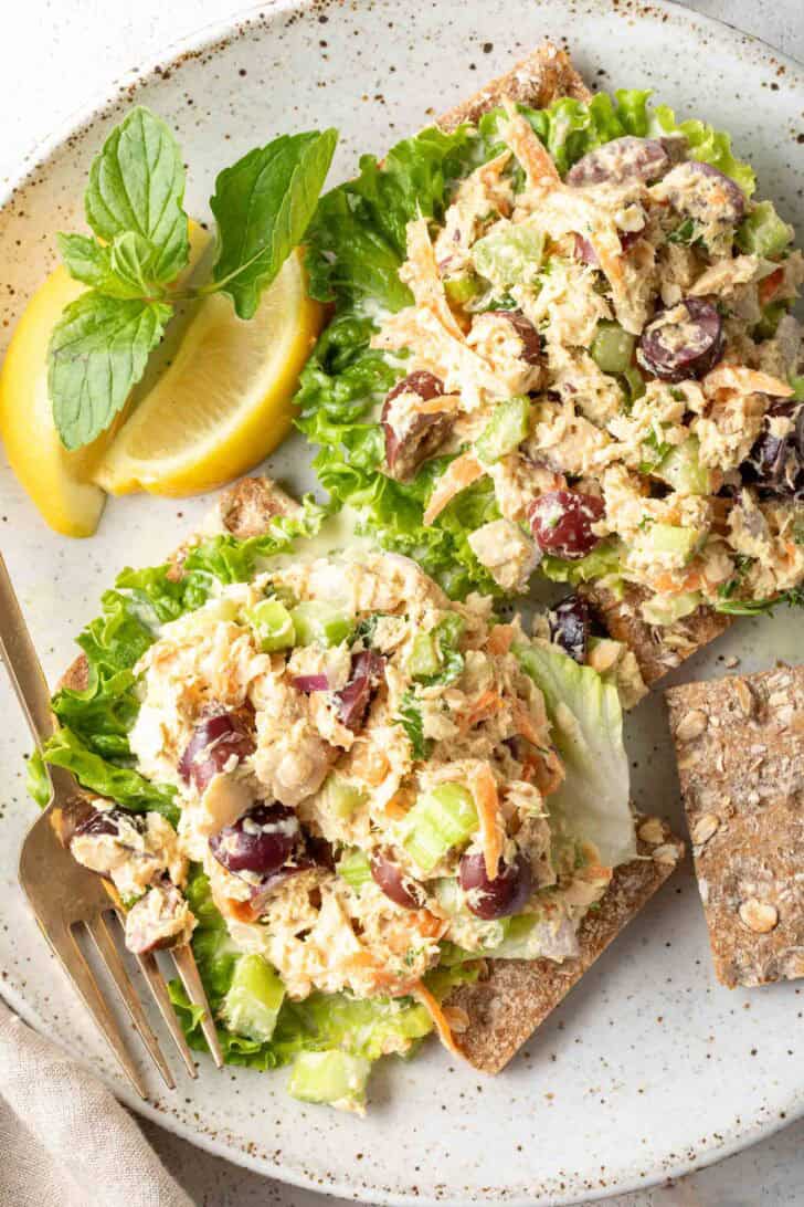 A white plate with two scoops of salmon salad on lettuce leaves.