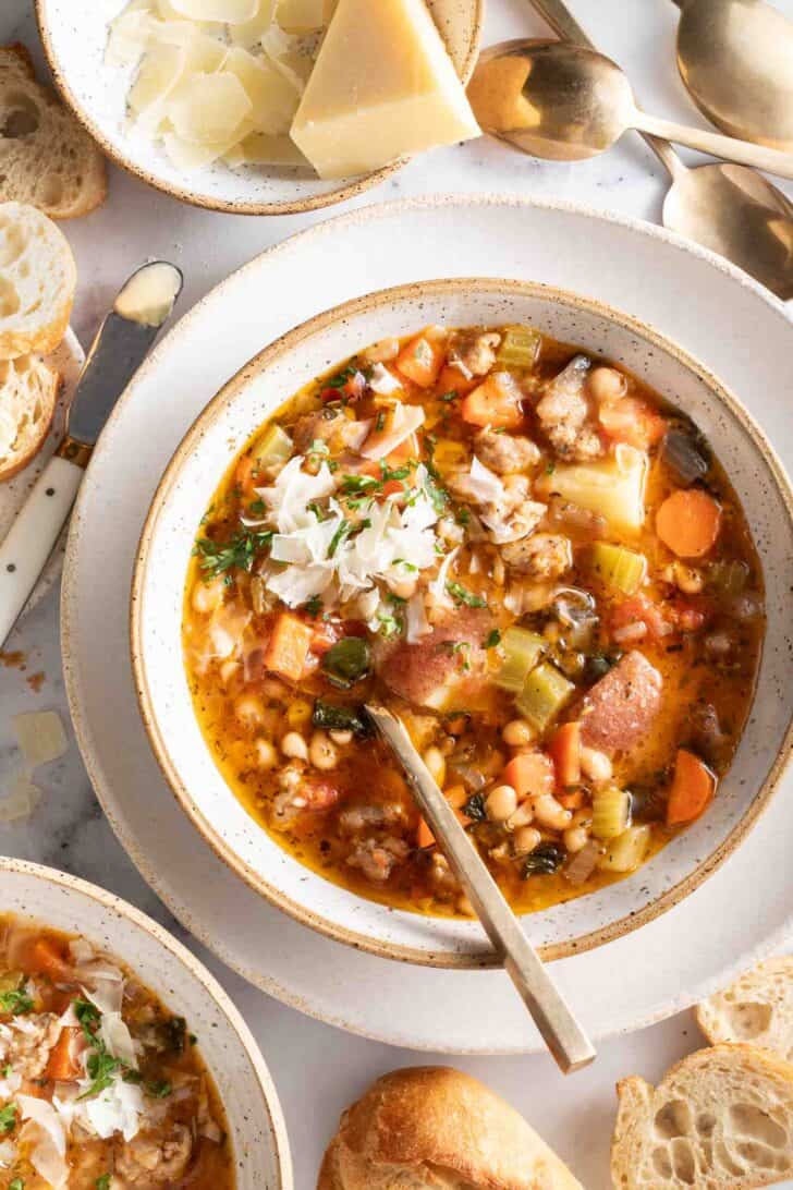 A white bowl filled with Sausage Kale and White Bean Soup.