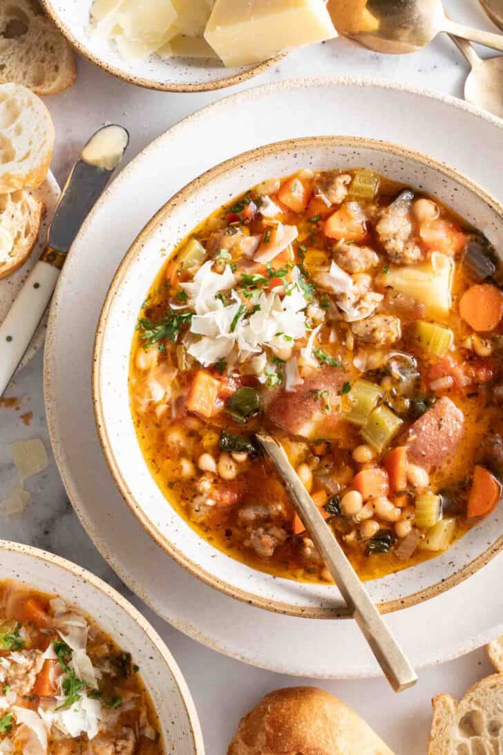 A white bowl filled with a Sausage White Bean soup.